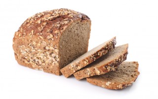 Sliced homemade brown bread with cereals. Isolated over white